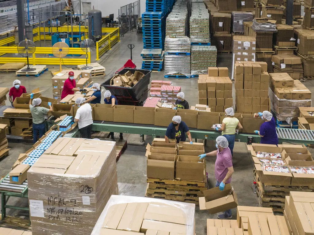 Workers packing boxes on a pack-out line